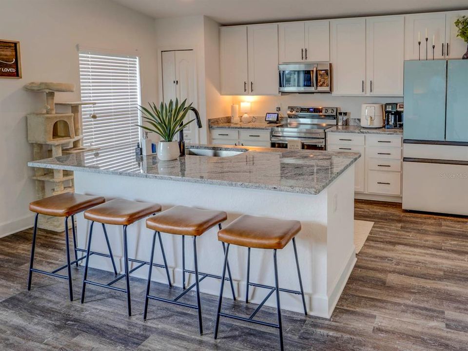 Kitchen area with quartz countertops. Luxury Vinyl Plank Floors.