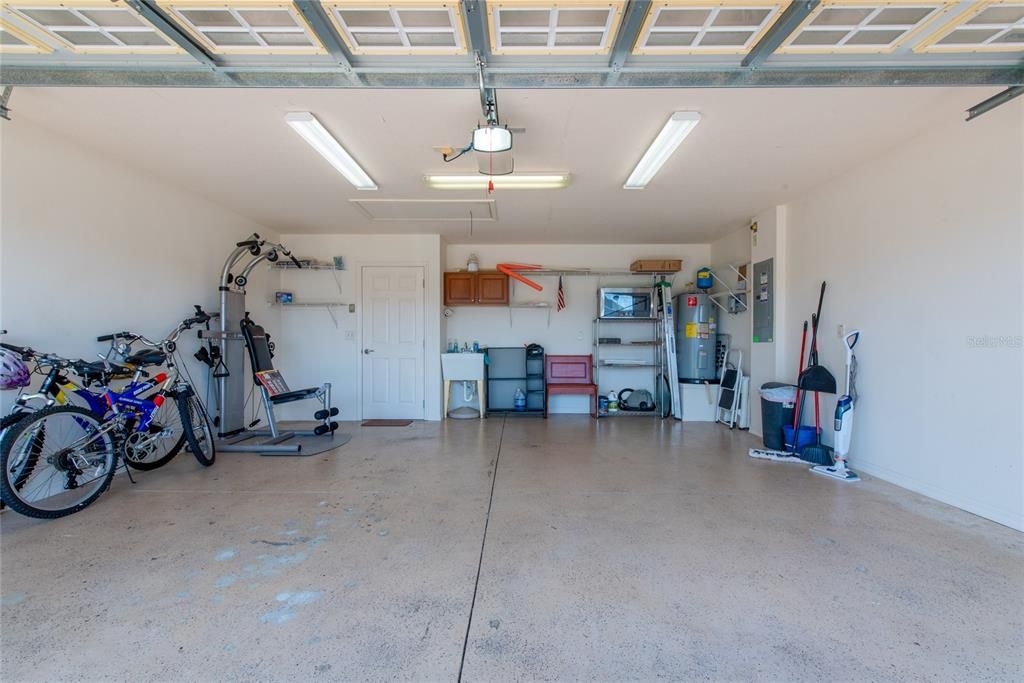 2-car garage with sink, storage cabinet, and other shelving. Exercise machine and 2 bicycles are INCLUDED!