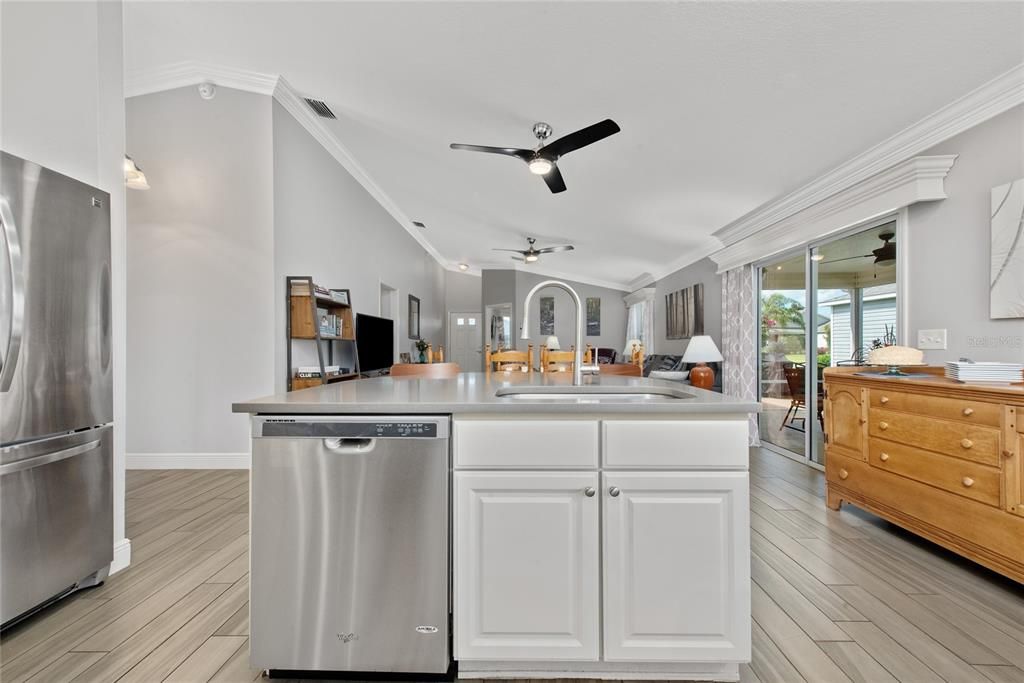 Kitchen view of dining & living room with slider doors to the outdoor screened lanai.