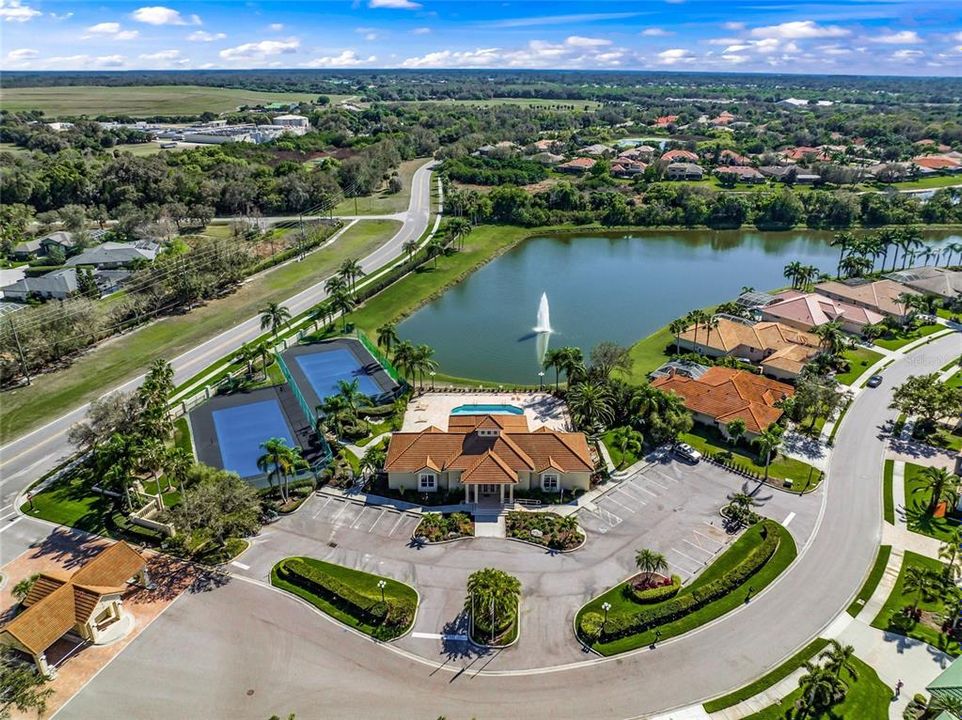 A view of the gated entrance with the community pool and club house straight ahead.