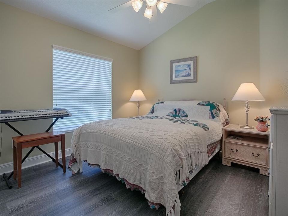 GUEST ROOM WITH LUXURY VINYL PLANK FLOORING AND VAULTED CEILING.