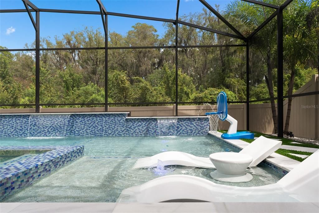 Resort-Style saltwater pool with glass mosaic tile throughout and sun shelves