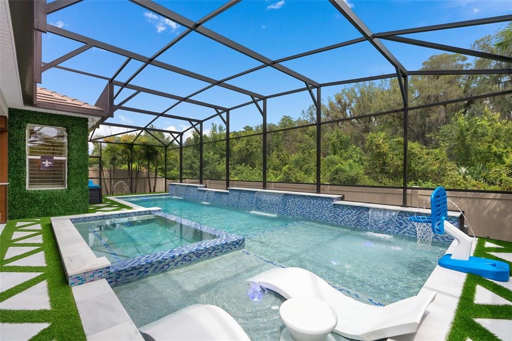 Resort-Style saltwater pool with glass mosaic tile throughout and sun shelves