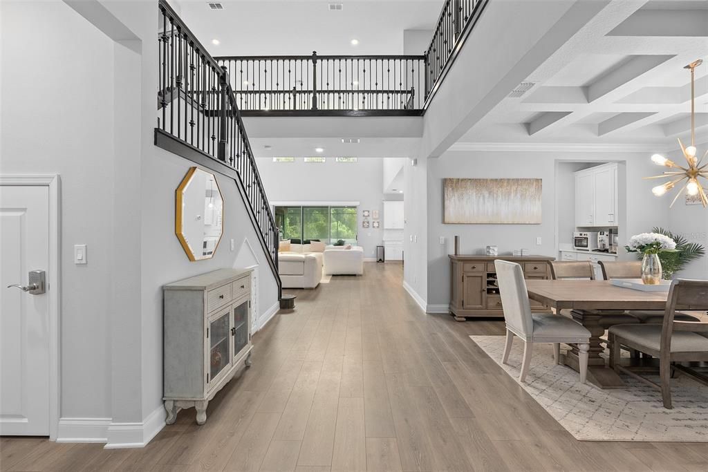 View from foyer of tall ceilings and dining and living room