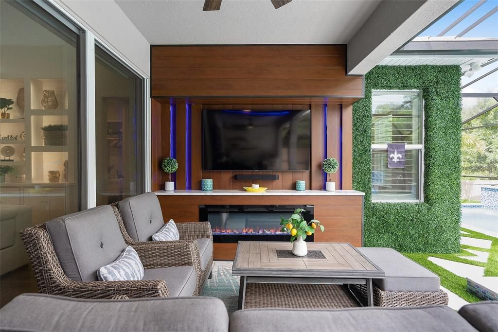 Outdoor living room with custom electric fireplace and led backlit wood-look wall