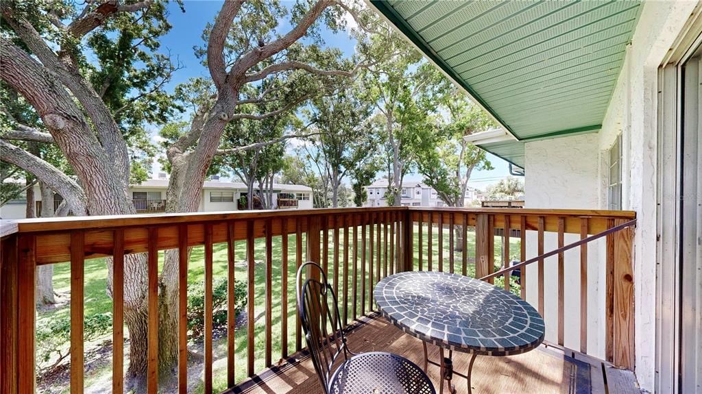 Beautiful patio overlooking the lush green space with trees.