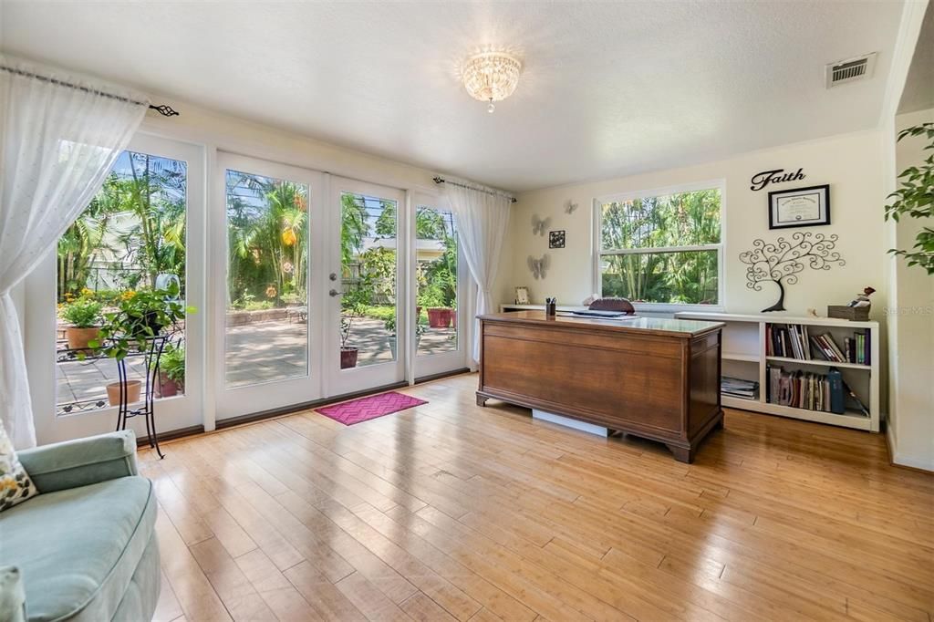 Bright and cherry sunroom with expansive views of tranquil back yard and French doors out to back yard oasis.