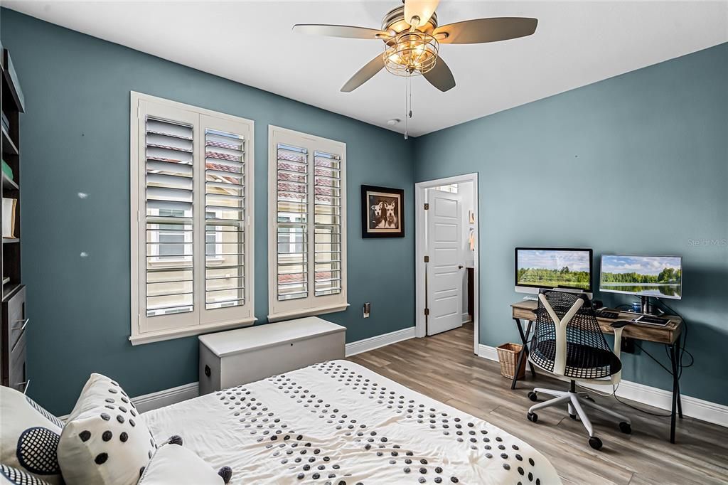 Second bedroom with large windows and plantation shutters