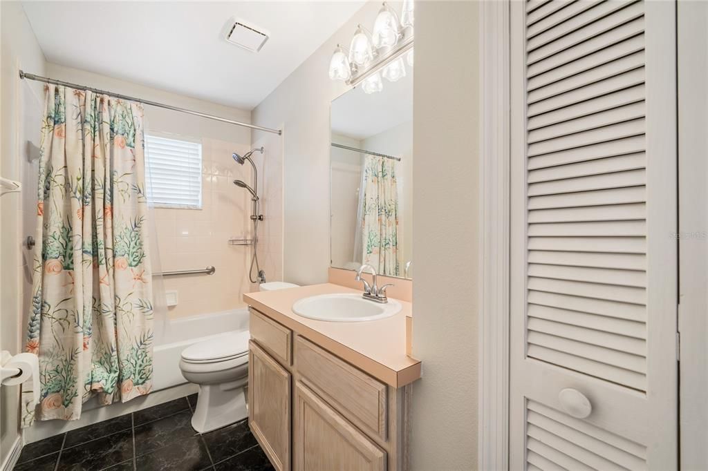 Light and bright guest bathroom with linen closet.