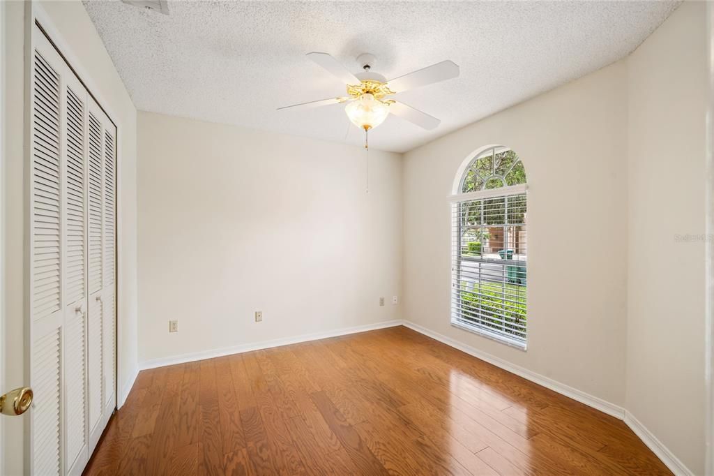 Second guest bedroom has a floor-to-ceiling arched window and engineered oak hardwood flooring.