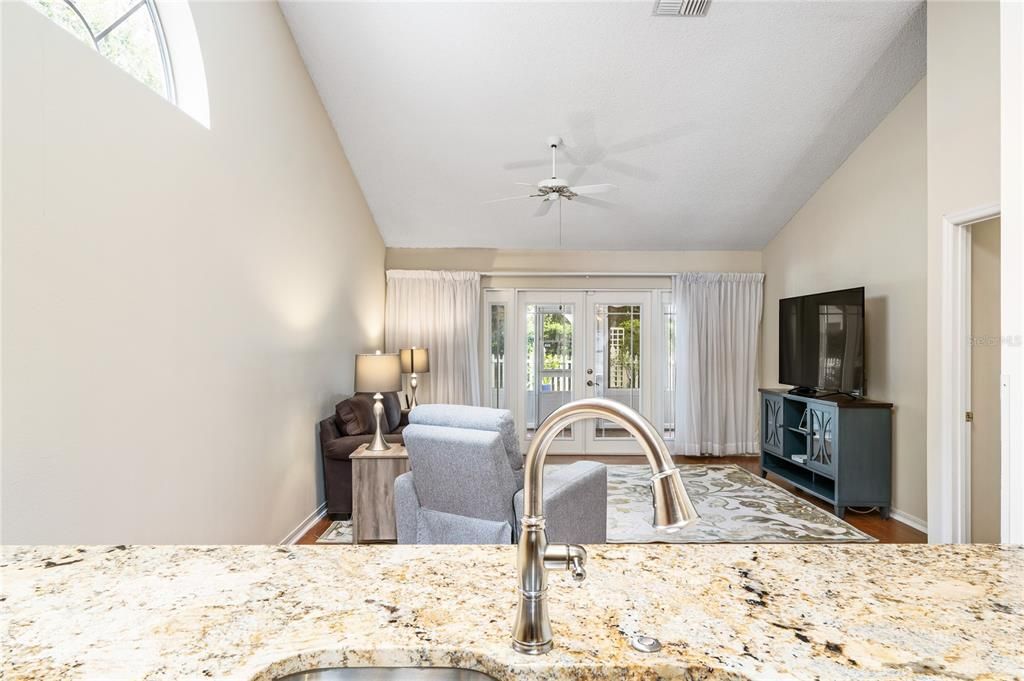 Efficient Kitchen with extended granite top overlooking the family room feels spacious with vaulted ceilings while a skylight provides abundant natural light