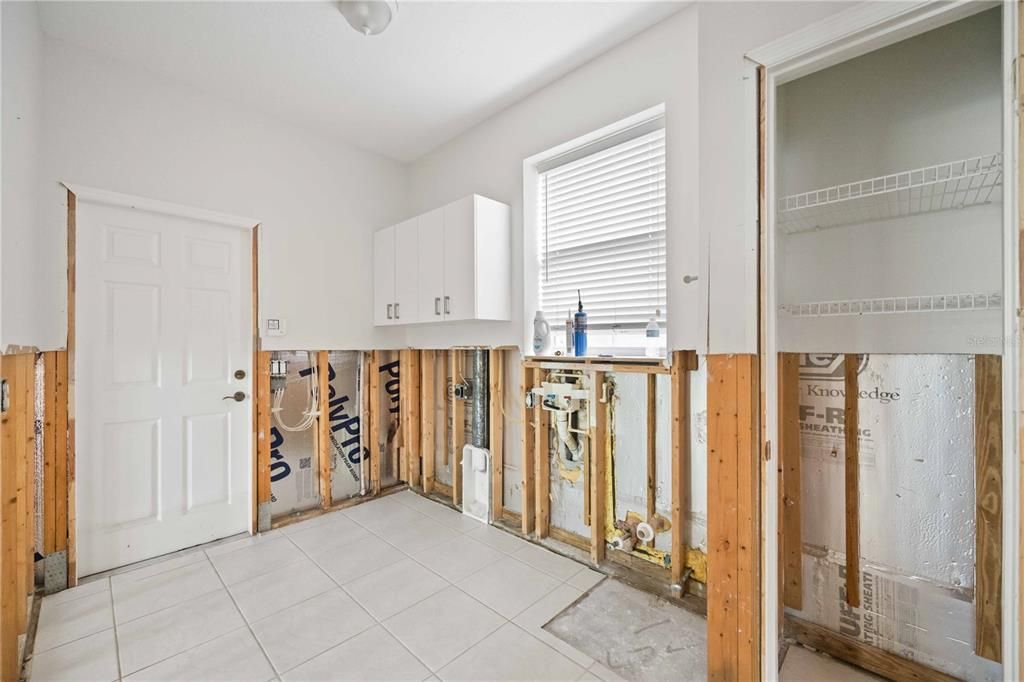 Laundry room with door that leads to the attached garage. Hookups for washer, dryer, and utility sink.