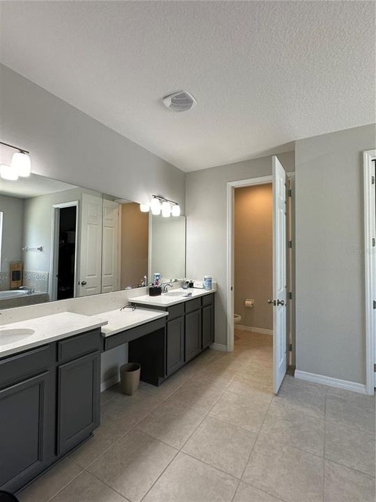 Primary Bathroom with Dual Vanities and Seating Area