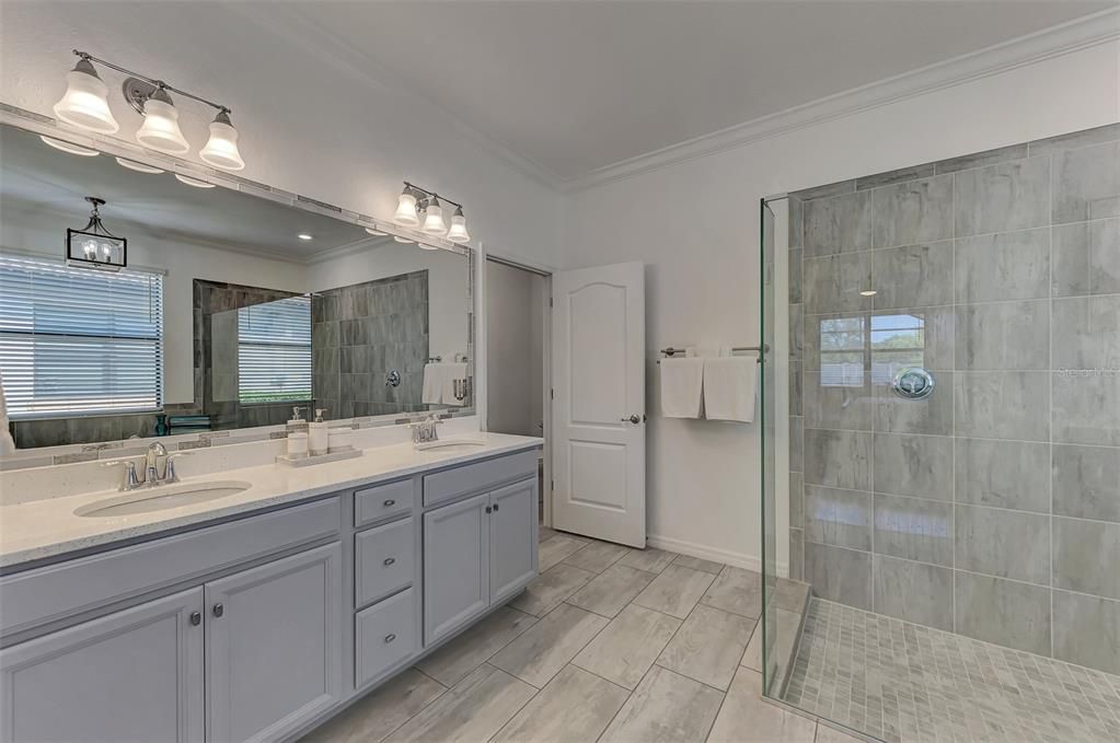 Primary Bathroom with double sink vanity, walk in shower, soaking tub, and separate water closet.