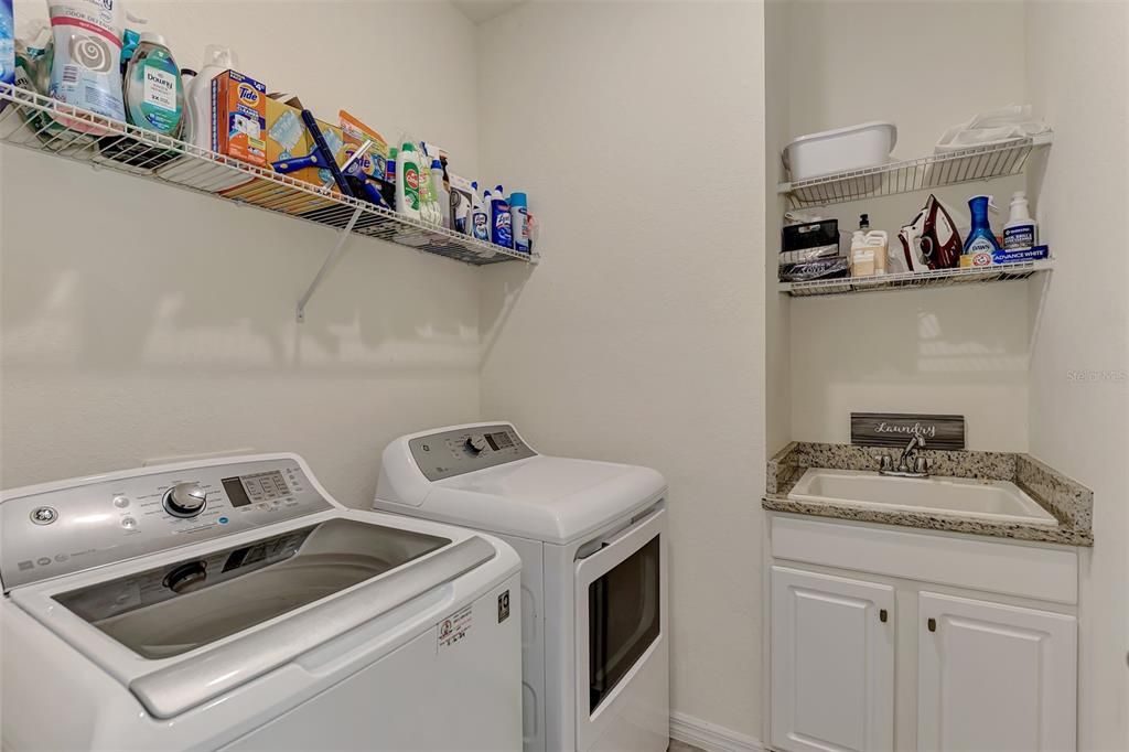 Laundry room with utility sink / storage shelves.