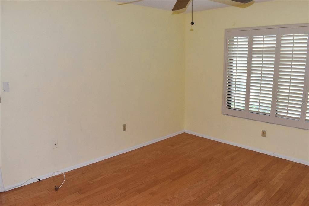 Master bedroom with hardwood floors & plantation shutters