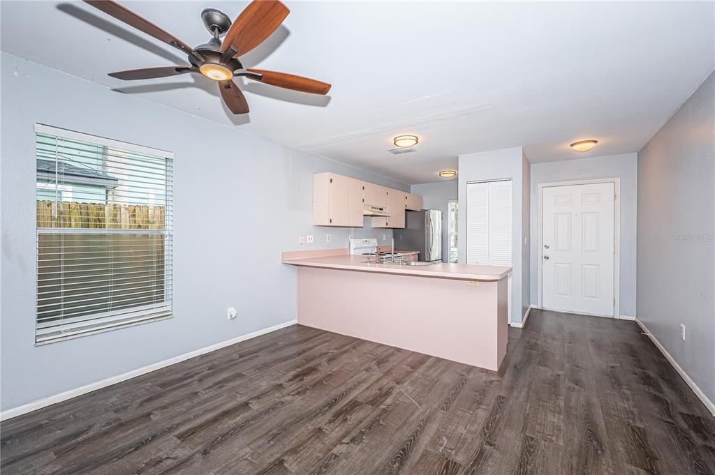 Kitchen, front entry and dining from living room with view of side yard