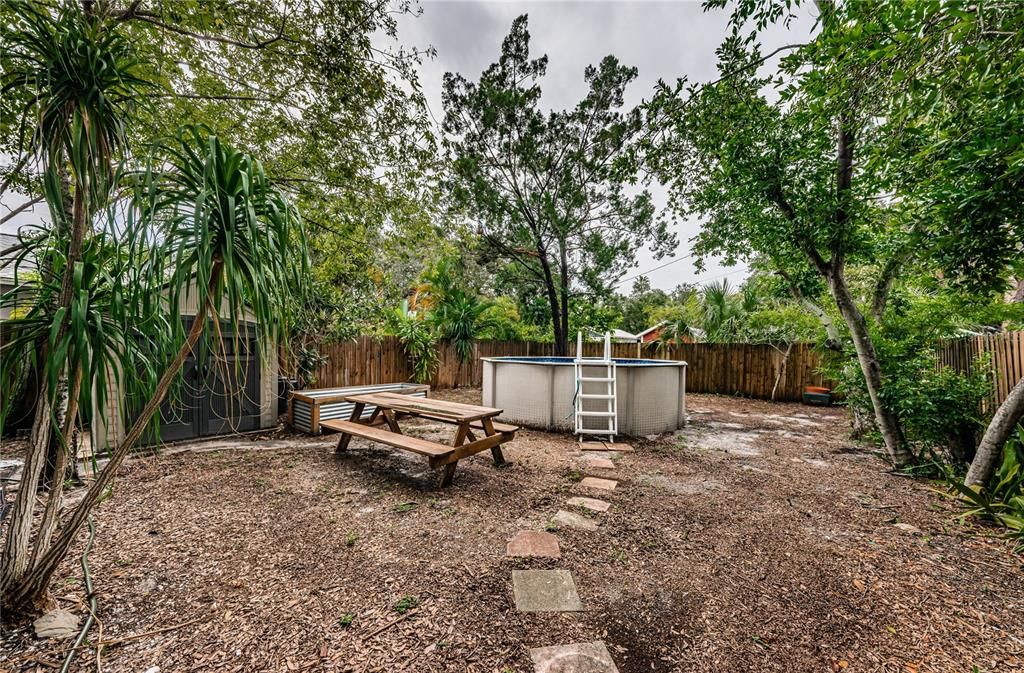 The back yard with shed, picnic table and above-ground pool