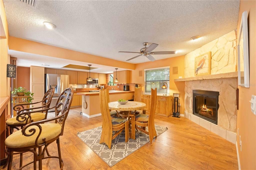 Between the Kitchen and Breakfast Bar is an eating area with wood burning fireplace