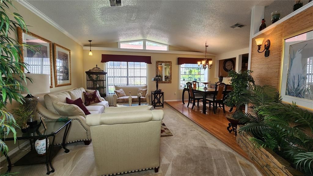 Front living room with vaulted ceilings and a view of the dining room off of the kitchen