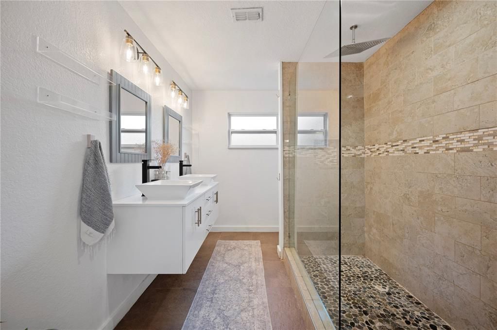 Upgraded bathroom with dual-sink floating vanity and walk-in shower