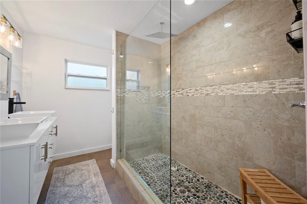 Upgraded bathroom with dual-sink floating vanity and walk-in shower