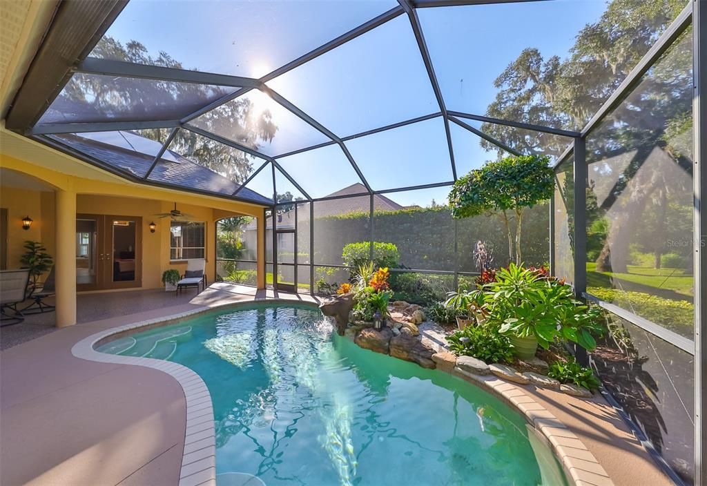 Pool surrounded by luscious landscaping.