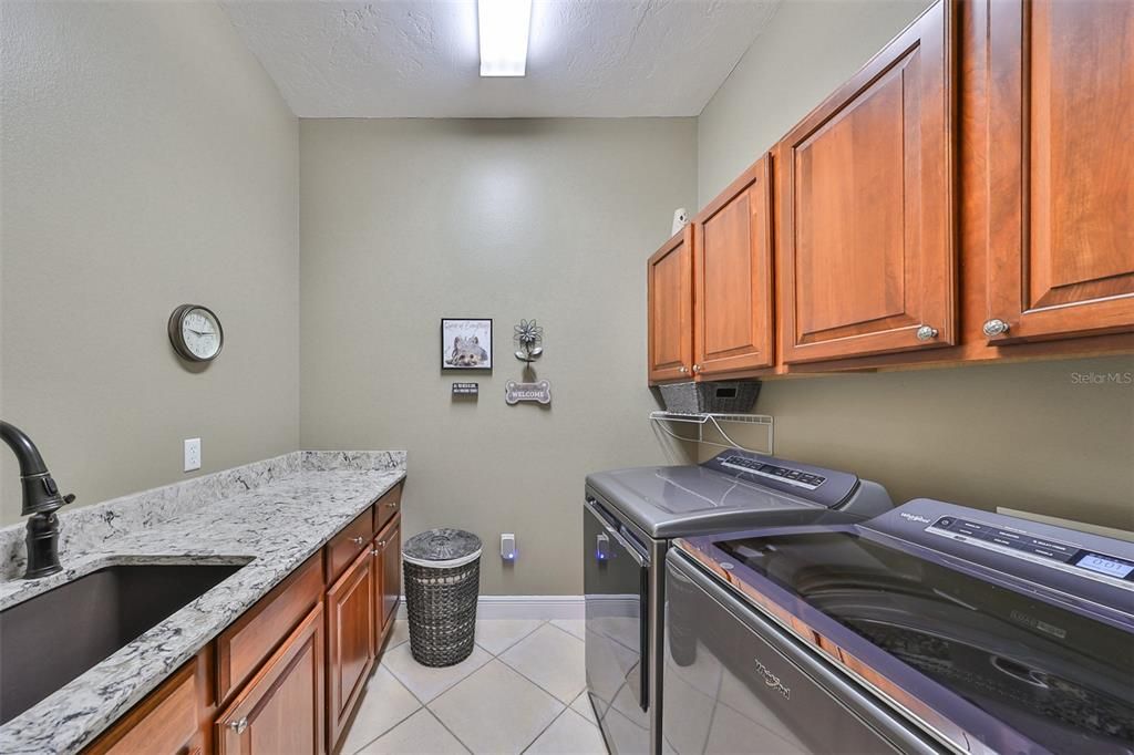 The prefect sized laundry room with sink, counter space and cabinets. Located off kitchen.