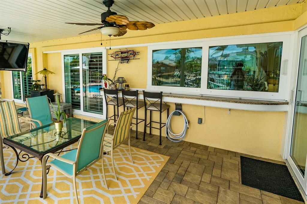 View from the patio of the kitchen pass through bar top.