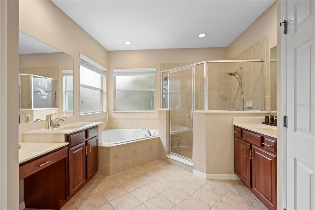 Lavish Primary Bath with his and her sinks, garden tub, separate large walk in shower