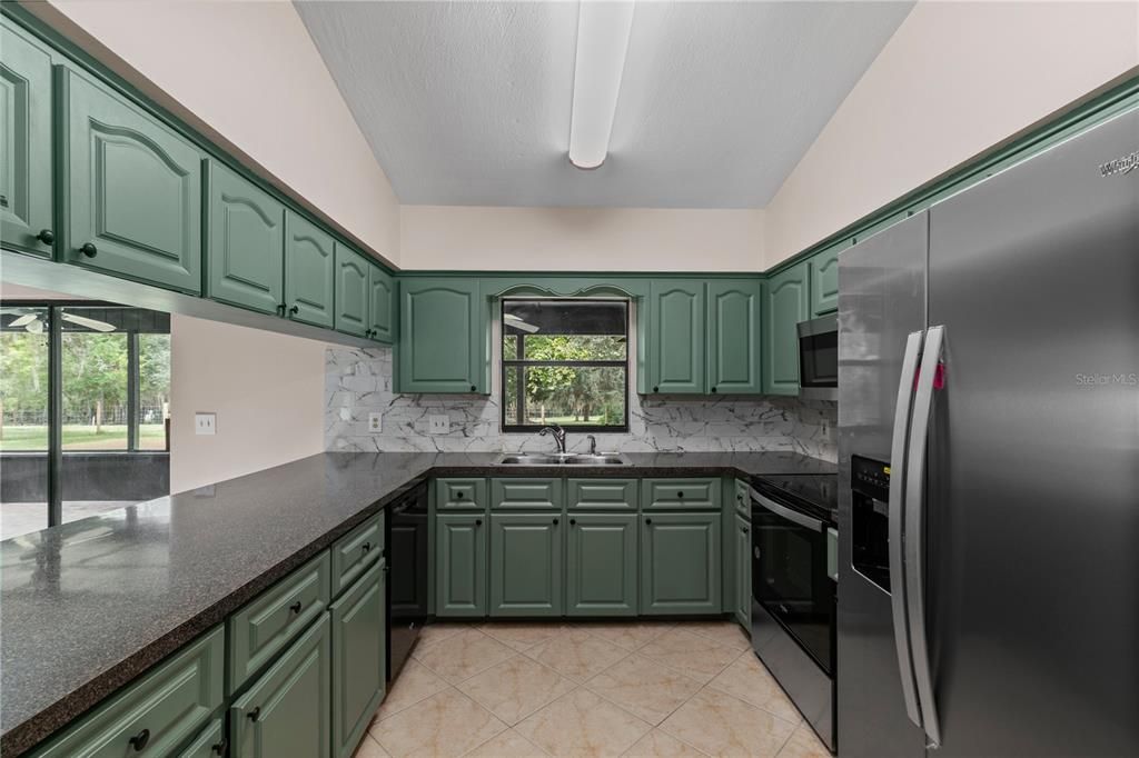 Kitchen with tile backplash and stainless appliances