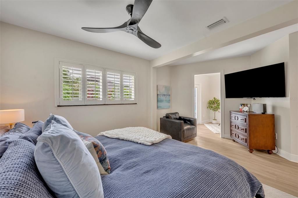 Primary Bedroom with Adjacent Office Space and Doors leading to Pool