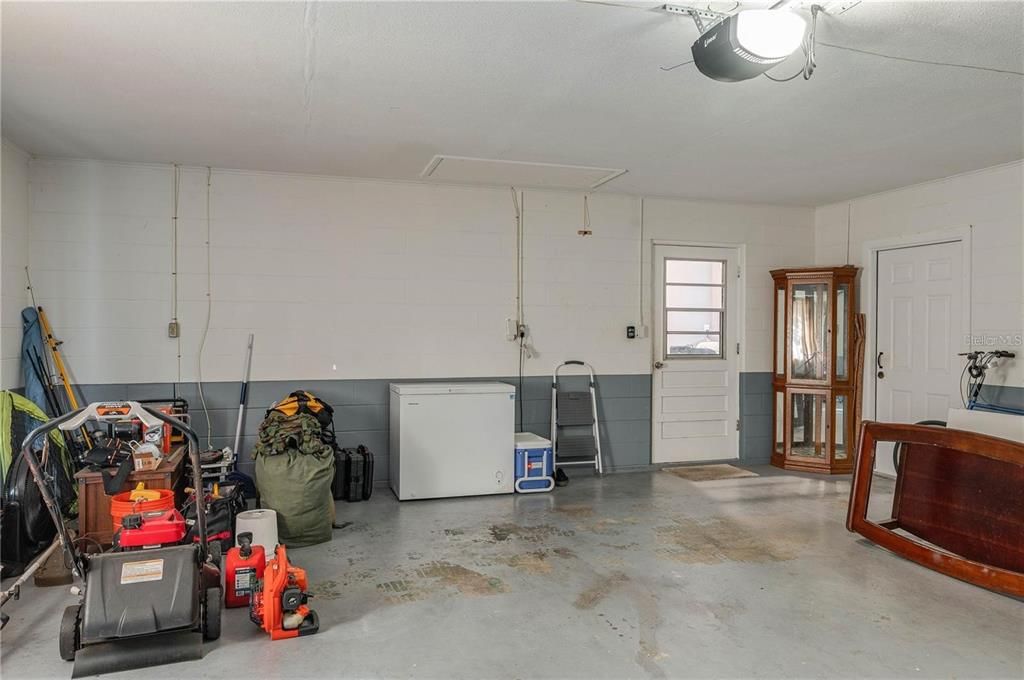 Garage showing exterior door, and entry door to laundry room and kitchen. Working garage door opener.