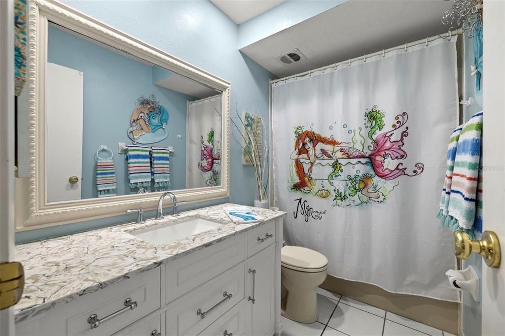 Secondary bathroom features recessed lighting, a tub-shower combo, newer vanity, fixtures and mirror.