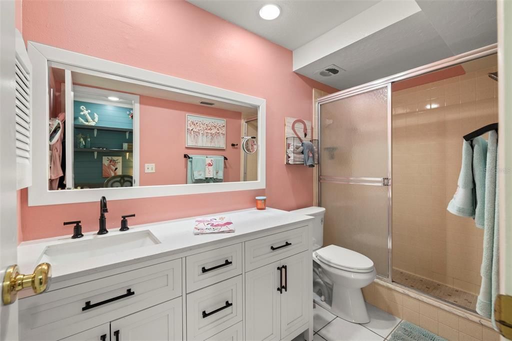 Primary en-suite bathroom with walk-in shower, newer bathroom vanity with soft close drawers, new vanity mirror, newer comfort height toilet and recessed lighting.