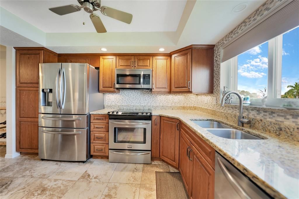 KITCHEN WITH GRANITE TOPS, STAINLESS APPLIANCES, VIEW FROM KITCHEN TO CANAL AND HARBOR