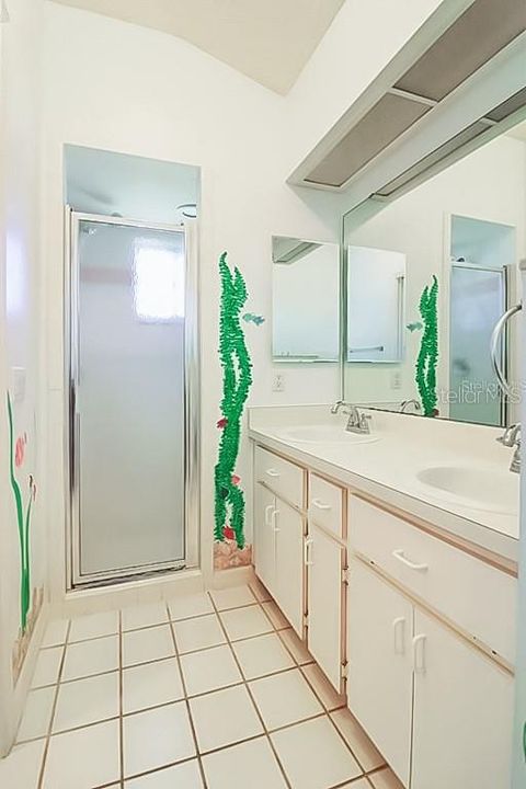 primary bath with dual sink vanity and shower