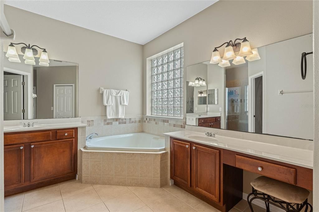 Spacious primary bathroom with garden tub, and double vanity sinks.