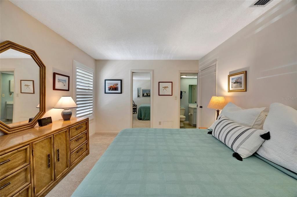 Primary Bedroom with views of closet with the mirror on the door and bathroom