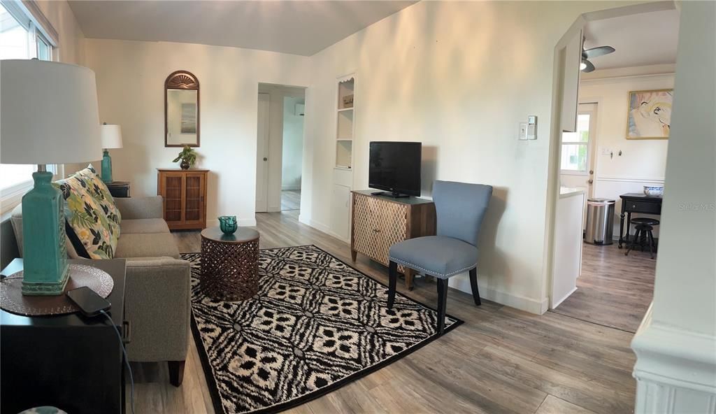 Living room with kitchen to right, bath and both bedrooms thru doorway in back