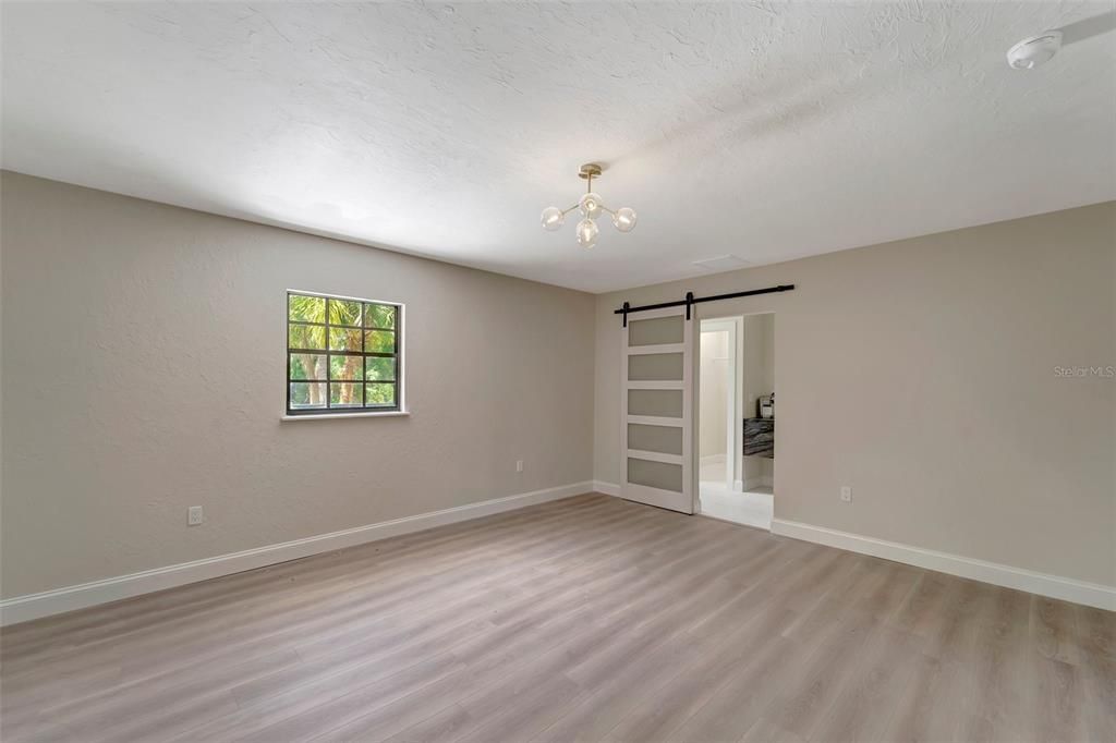 Main bedroom with LVP and sliding door to en-suite and walk in closet