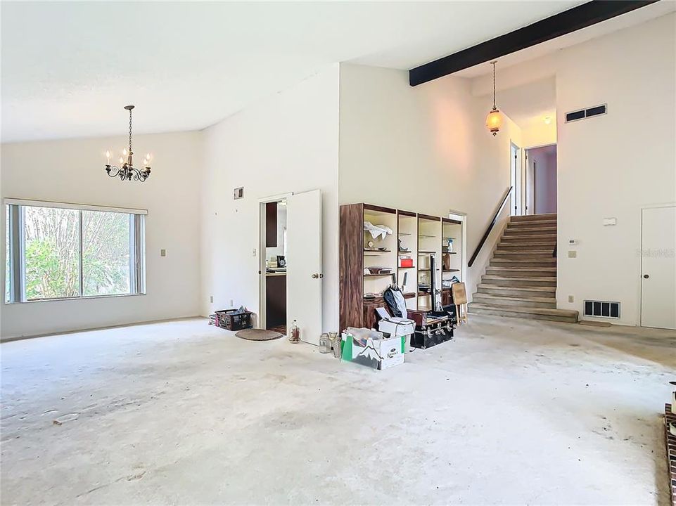 A view of the dining room, living room, and staircase taking you to the bedrooms.