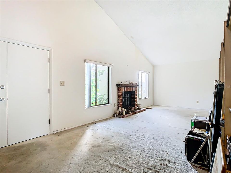 Enter into the living room with a wood burning fireplace.