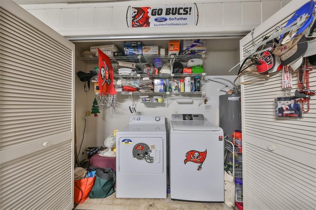 The washer and dryer has an area just for the laundry with shelving.