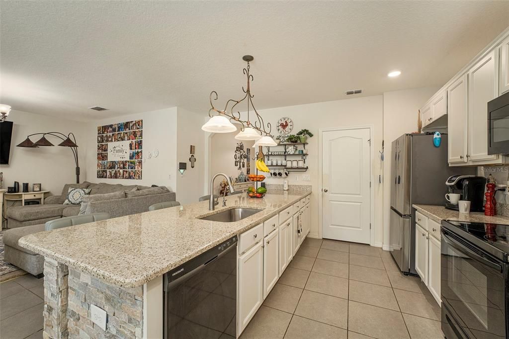 Open floor plan with breakfast granite bar opening to living room and eat in kitchen/dining room