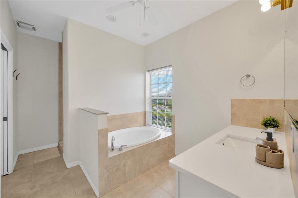 Soothe your soul in the relaxing garden tub and dual sinks set in a lovely quartz countertop.