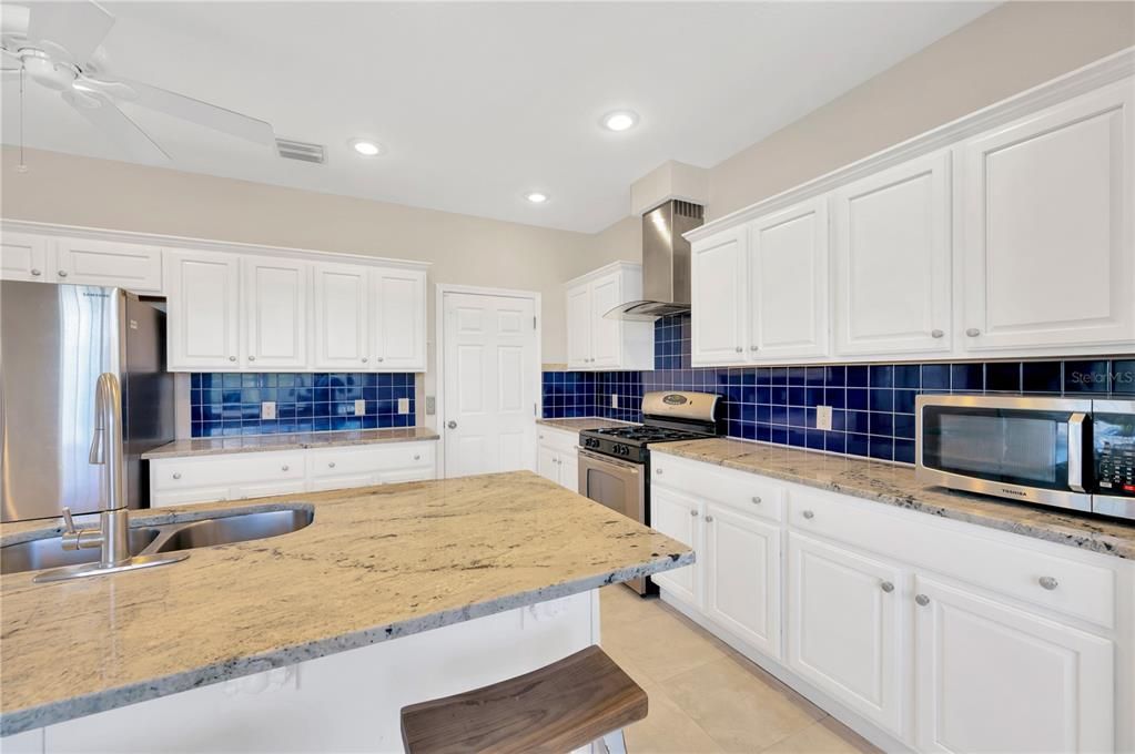 This open kitchen has 2 pantries and gives off Santorini vibes with its rich color scheme of white and mediterranean blue.