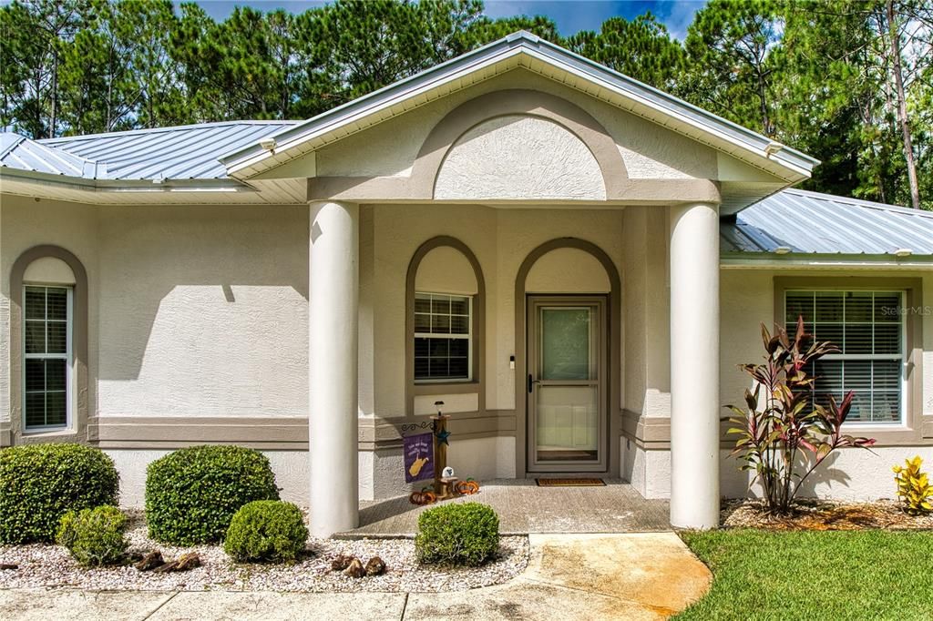 Handsome Front Entry with Elegant ColumnsThis striking front entry welcomes you with rounded framing columns, adding a grand architectural touch. The covered entry provides shelter and a polished look, perfect for enhancing curb appeal. The front door features between-the-glass blinds for added privacy and light control, while the storm door offers extra protection and energy efficiency. Beautifully tiled for that added touch of sophistication, this entryway combines style with functionality, making a lasting first impression.