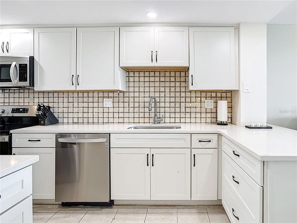 Your kitchen has been completely updated.  You will notice the newer cabinets. the designer backsplash and the Corium countertops.