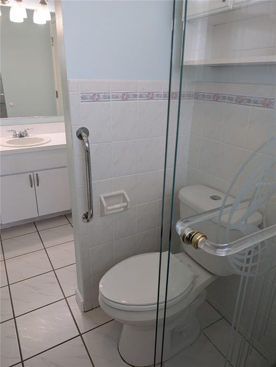 Master bath features grab bars, comfort height commode and toiletry storage cabinet.